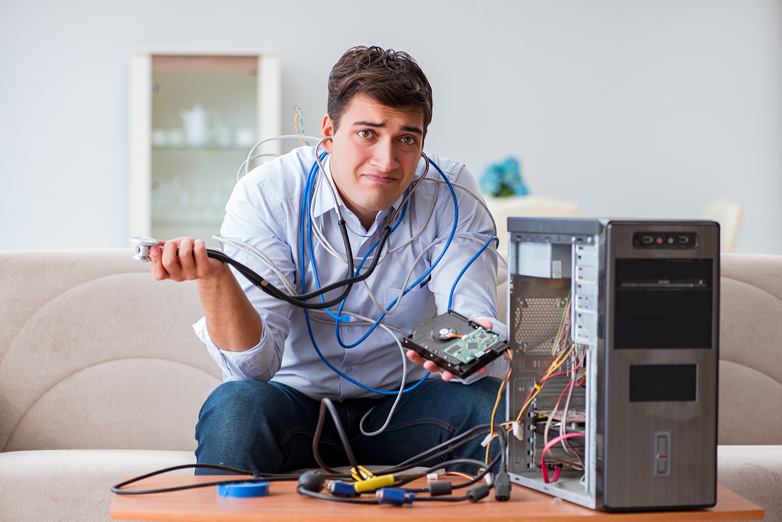 Frustrated man with broken PC trying to recover files from hard drive