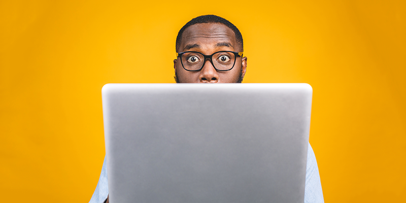 Man behind laptop yellow background article image